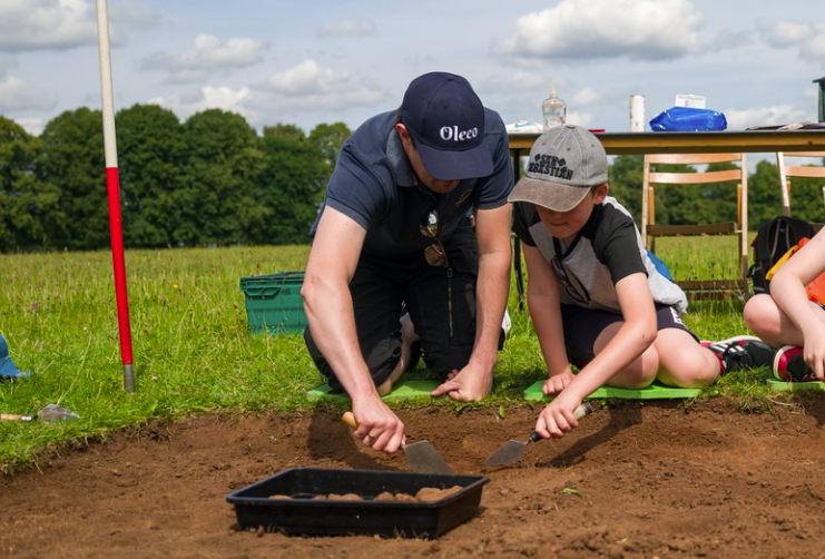 Parent and child digging with an archaeological trowel