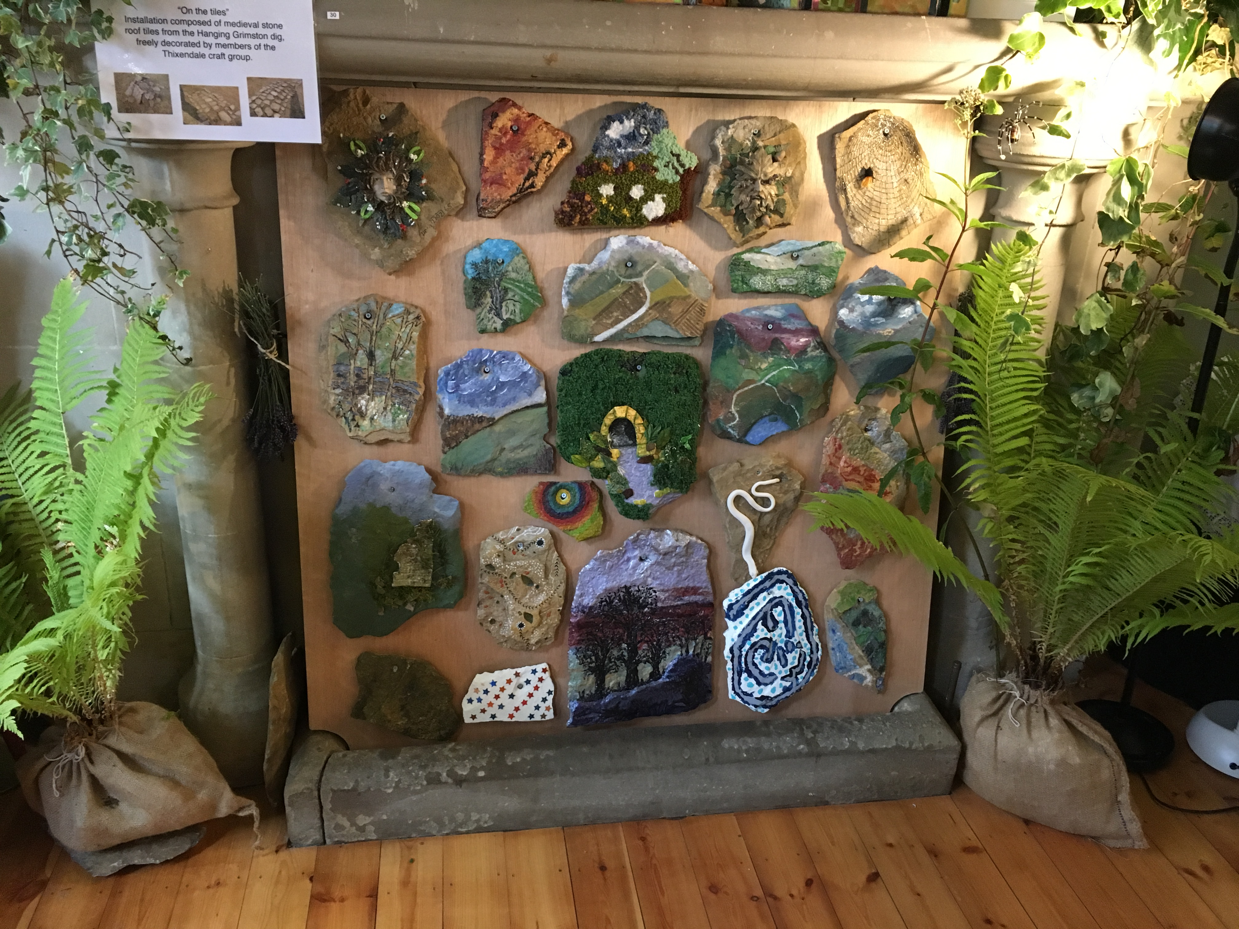   a display of various pieces of roof tiles that are decorated and hanging on a wall