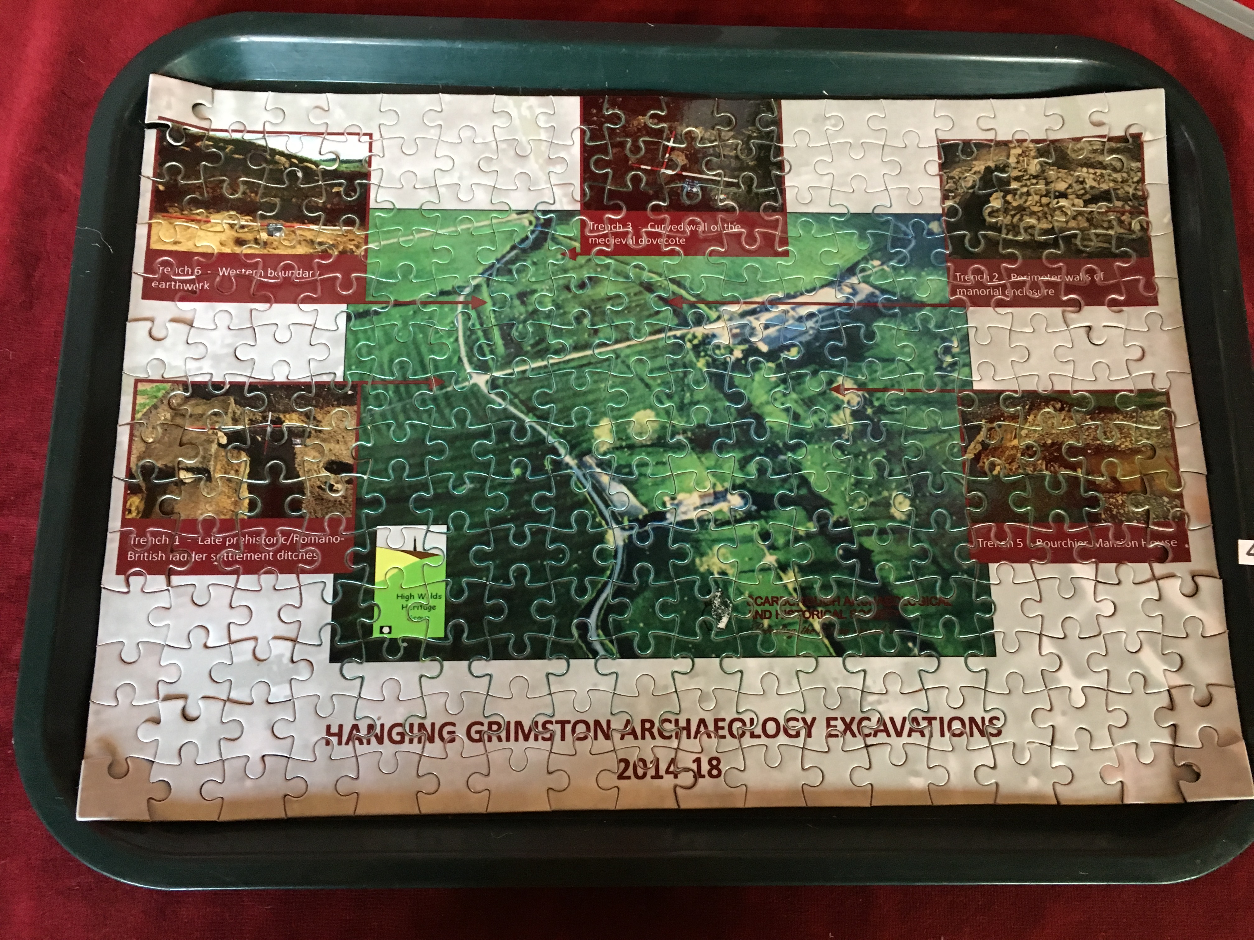 jigsaw puzzle on a tray with images of a field and archaeology