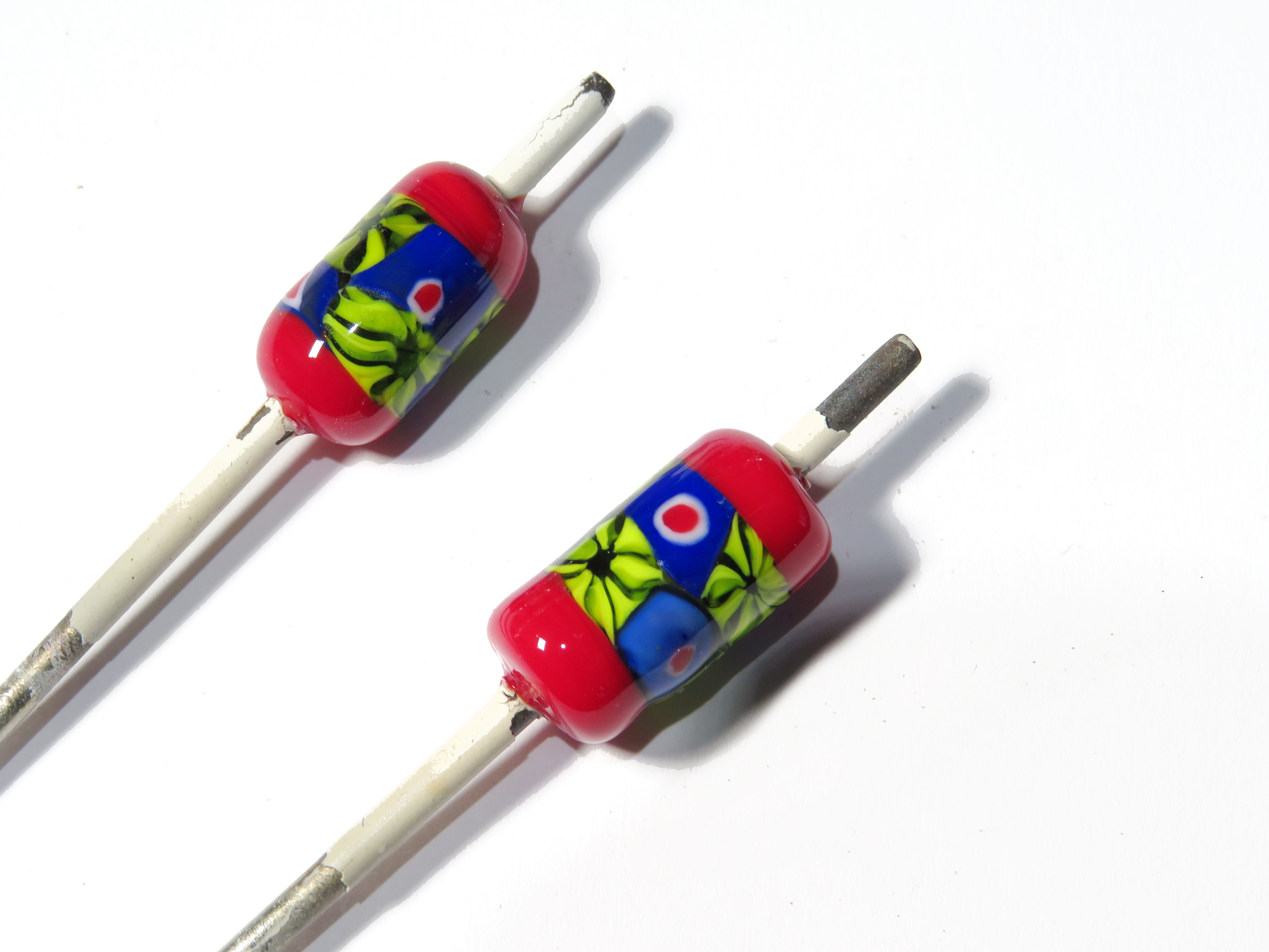 a close-up of some glass beads on metal sticks. 